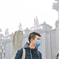北京昨日霧霾嚴重，兩名男子佩戴口罩出行。（中新社圖片）