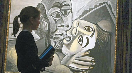 托馬斯生前在西班牙已故畫家畢加索的作品前留影。（互聯網圖片）