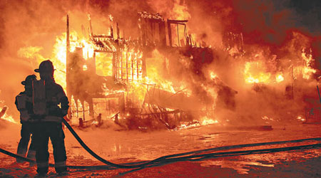 建築物陷入一片火海，消防員不斷射水救火。（互聯網圖片）