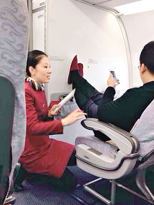 男乘客無視空姐勸阻繼續玩手機。（互聯網圖片）