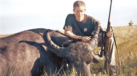 英國傳媒刊登哈利○四年持槍與被獵殺的水牛合照。（互聯網圖片）