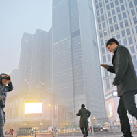 天津市民在霧霾籠罩中生活。（中新社圖片）