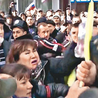 親俄羅斯的示威者扯下烏克蘭國旗。（互聯網圖片）