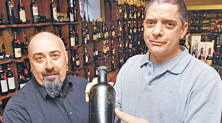 拉塞爾斯（右）與另一名別墅擁有人展示冧酒。（互聯網圖片）