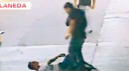 萊斯卡諾（白衫）遭工人從橋上擲下後，倒臥地上。（互聯網圖片）
