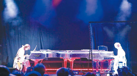 Yoshiki的影像首先出場為觀眾演奏，隨後他的真人亦坐在對面的鋼琴前彈奏（左）。（互聯網圖片）