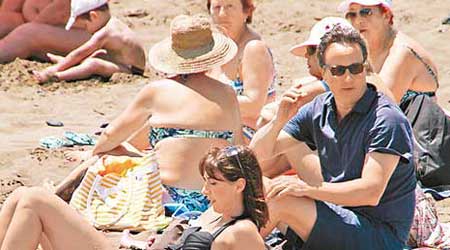 卡梅倫（右二）在西班牙海灘度假時被水母螫傷。（互聯網圖片）