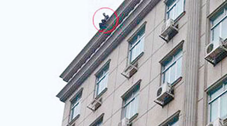 男子曾在樓頂危坐（圖），最終墮落檢察院接待中心門外身亡。（互聯網圖片）