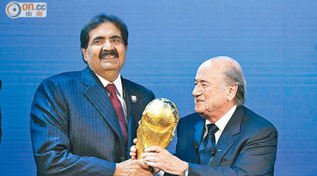 當年申辦成功後，時任卡塔爾國王哈馬達（左）由白禮達（右）手上接過獎盃。