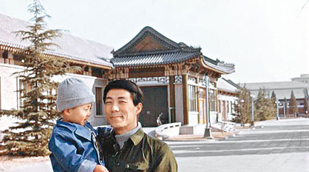 李望知小時候與父親薄熙來的合照。（互聯網圖片）