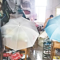 圖為湖南商學院學生將傘撐在書桌上保護書本和衣物等。（中新社圖片）