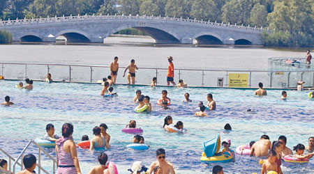 北京朝陽公園昨開幕的海洋沙灘狂歡活動，吸引大批市民到來避暑。（中新社圖片）