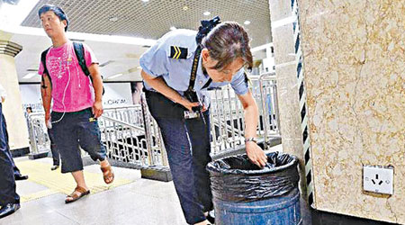 北京地鐵站女職員檢查站內垃圾桶。（互聯網圖片）