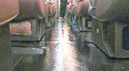 澳航客機機艙漏水，座位間的通道有如河流。（互聯網圖片）