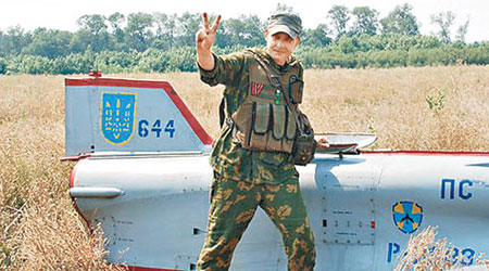 一名疑似親俄分子站在無人機殘骸上拍照，舉起勝利手勢。（互聯網圖片）
