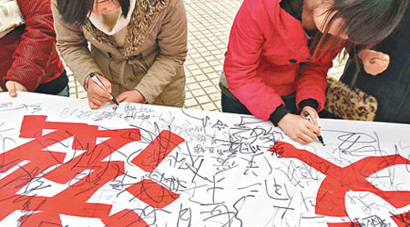 河南高校的大學生早前簽名宣傳防愛滋病。