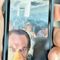 有乘客在滿布濃煙的機艙內自拍。（互聯網圖片）