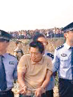 劉姓疑犯（左二）被押到事發現場重組案情。（互聯網圖片）