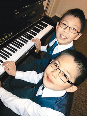詹姆斯‧陳（前）年紀輕輕，琴技卻十分高超。圖後是他的弟弟謝利美。（互聯網圖片）