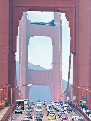 一架戰機高速飛越金門大橋，約一百二十一米下的橋面滿布汽車和行人。（互聯網圖片）
