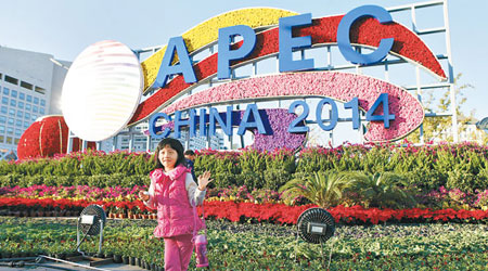 一名女孩在APEC主題花壇前留影。（中新社圖片）