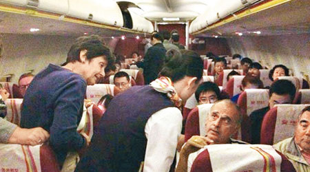 空姐向乘客解釋未能降落北京機場的原因。（互聯網圖片）