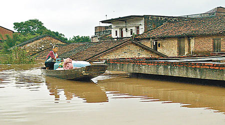 村莊屢被水浸，村民將物品運到小船上。（互聯網圖片）