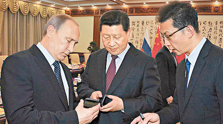 普京（左）向習近平（中）送上俄產最新型號智能手機YotaPhone 2。（互聯網圖片）