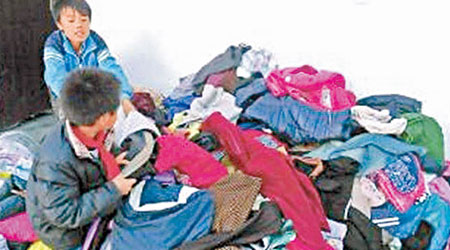 四川山區小學獲贈的舊衫堆積如山。（互聯網圖片）