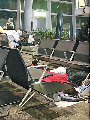 編號183客機的乘客最終獲准返回機場，席地而睡。（互聯網圖片）