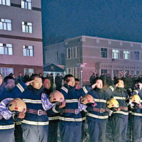 消防官兵面向靈車隊伍脫帽敬禮。（中新社圖片）