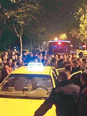 南京多區發生打砸、阻撓的士營運的情況，圖為大批民眾包圍的士。（互聯網圖片）
