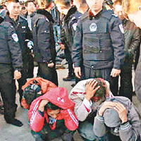 數名鬧事者被警方制服，蹲在地上。（互聯網圖片）