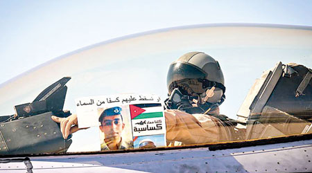 約旦機師出征前手持卡薩斯巴的照片致意。（互聯網圖片）