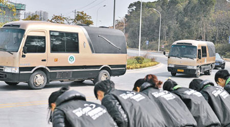 廈門福澤園殯儀館工作人員在門口向運載死難者遺體的車輛鞠躬。（中新社圖片）