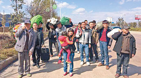 大批被欠資的農民工拿着行李徒步回鄉。（互聯網圖片）
