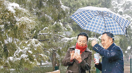 北京市民在雪中暢遊地壇廟會。（中新社圖片）
