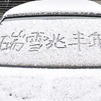 北京雨雪天氣持續，路人在汽車上寫下「瑞雪兆豐年」。（互聯網圖片）
