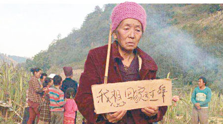 一名老婦人舉着「我想回家過年」標語。（互聯網圖片）