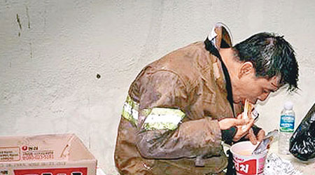 消防員低着頭吃杯麵的照片被網民瘋傳。（互聯網圖片）
