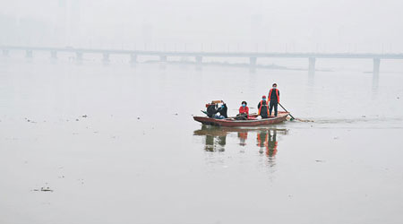 水務局工作人員在贛江打撈垃圾。（中新社圖片）