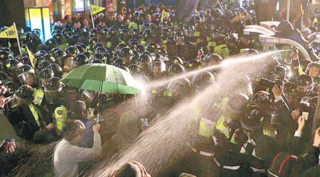 光化門警員向示威民眾施放胡椒噴霧。（互聯網圖片）