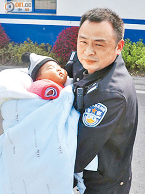 警員抱起被遺棄的嬰兒。