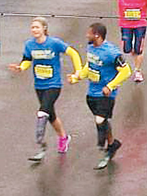 教練牽着格雷戈里（左）的手，慢慢跑到終點。（互聯網圖片）
