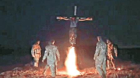 豎起十字架後，武裝分子在下方縱火。（互聯網圖片）