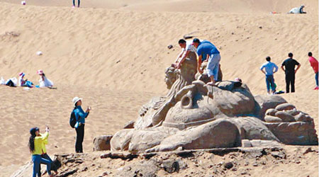 遊客肆意攀爬沙雕拍照。（互聯網圖片）