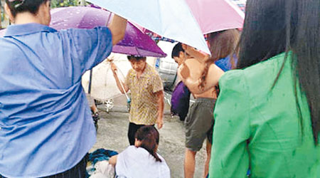 街坊為蔣女士撐傘擋風雨。（互聯網圖片）
