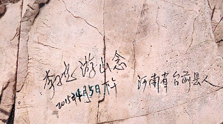 缺德遊客在山壁寫下自己的姓名。（互聯網圖片）