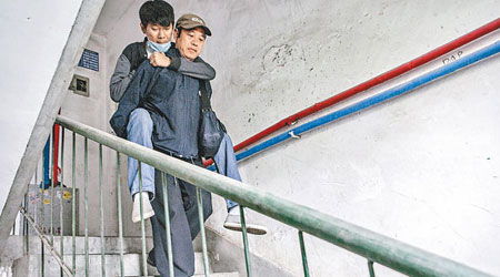 王純平孭着兒子下樓前往輸血。（互聯網圖片）