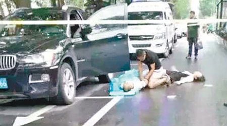 一名男子跪在死者身旁查看，旁邊女子暈倒躺在地上。（互聯網圖片）